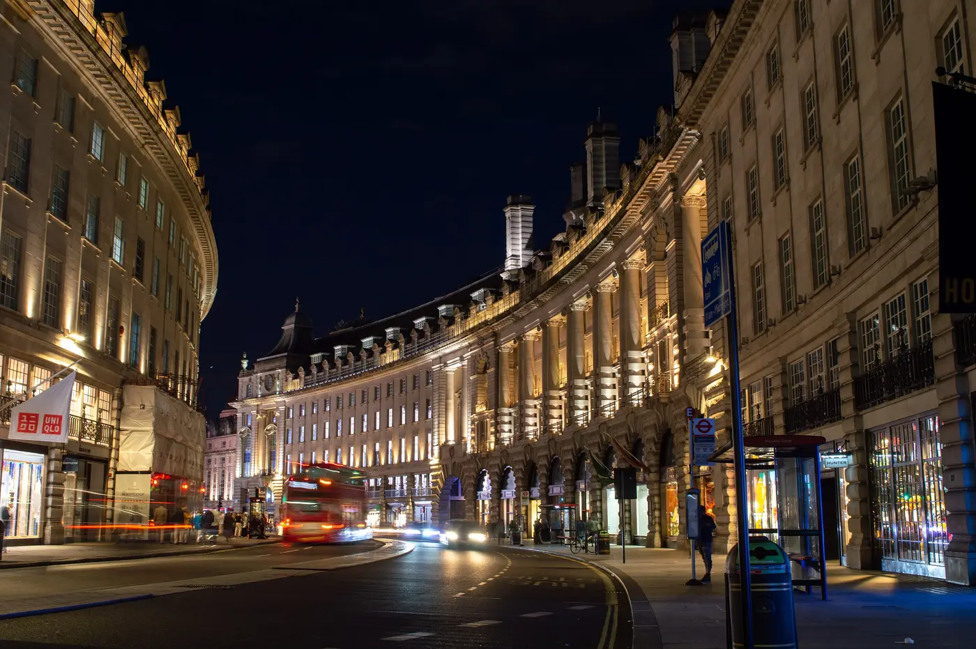 Regent Street at night, its curved facades lit up above streaks of traffic